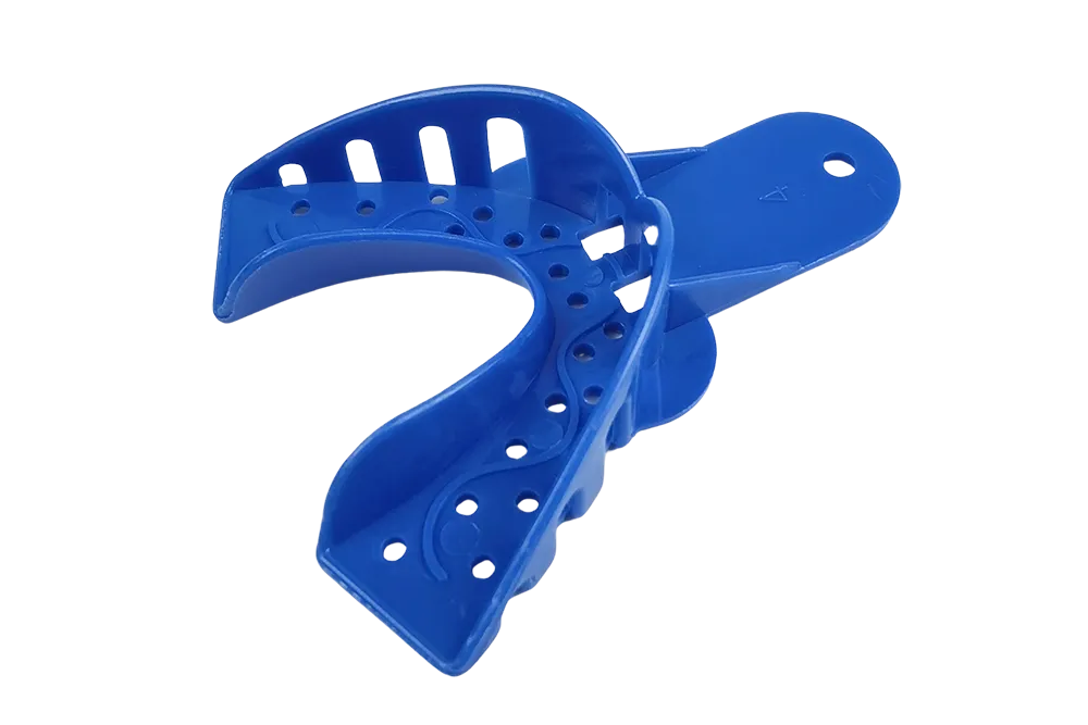 A collection of professional-grade plastic dental impression trays, including perforated, solid, and quadrant types, arranged on a clinical blue tray